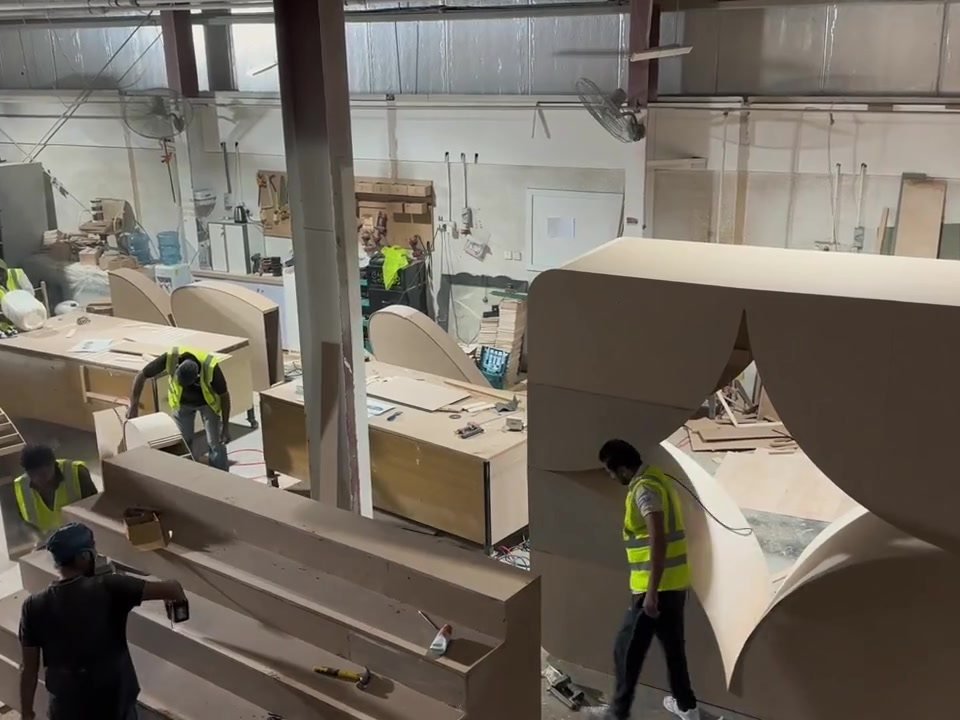 Workshop floor with the carpentry team building large curved timber structures