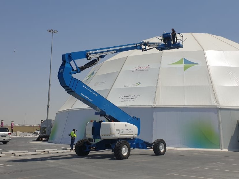 Installation crew on a boom lift fitting branding panels to a dome structure