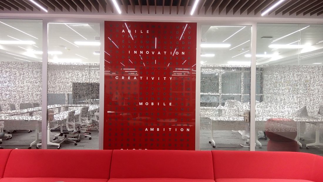 Red office feature wall with word graphics and patterned glass film