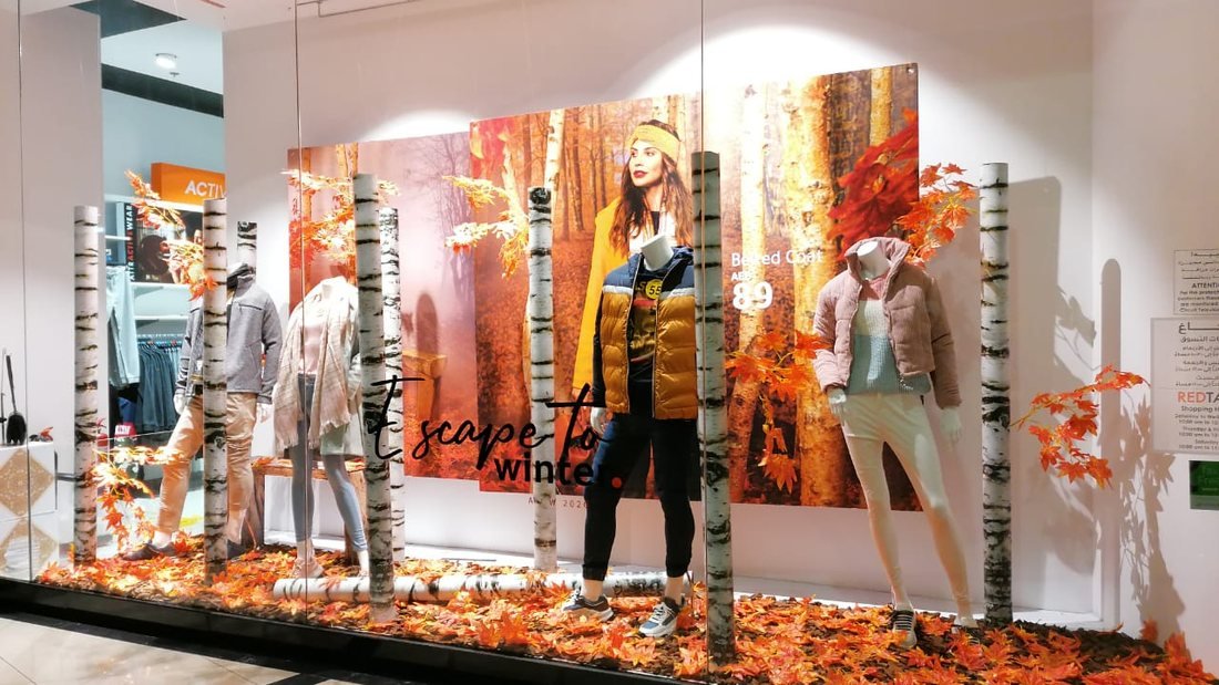 Seasonal shop window with printed backdrop and fabricated tree props