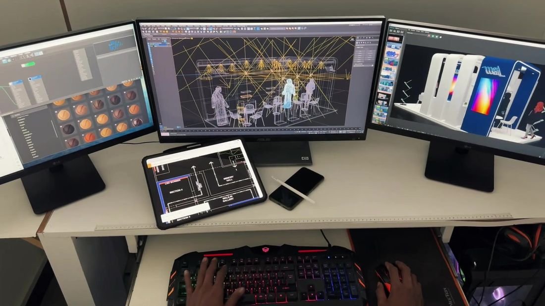 Designer reviewing a 3D layout across three monitors