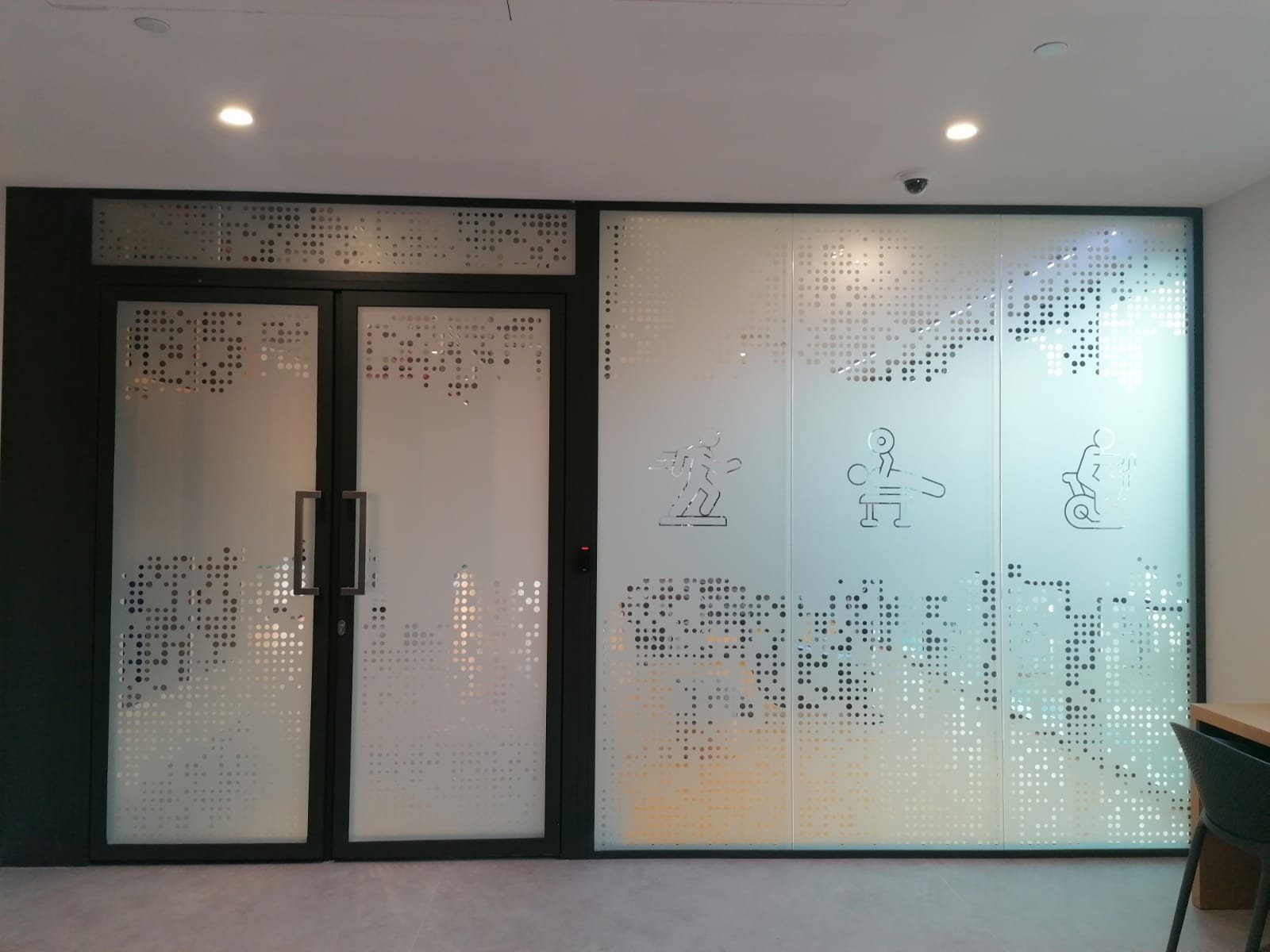 Frosted dot-pattern glass film with fitness icons on gym doors