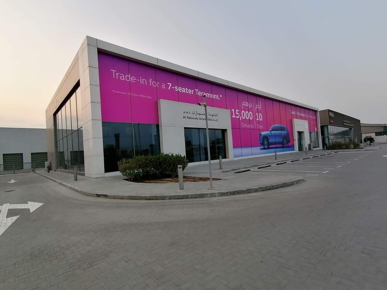Pink Volkswagen Teramont campaign graphics across an Al Nabooda showroom facade